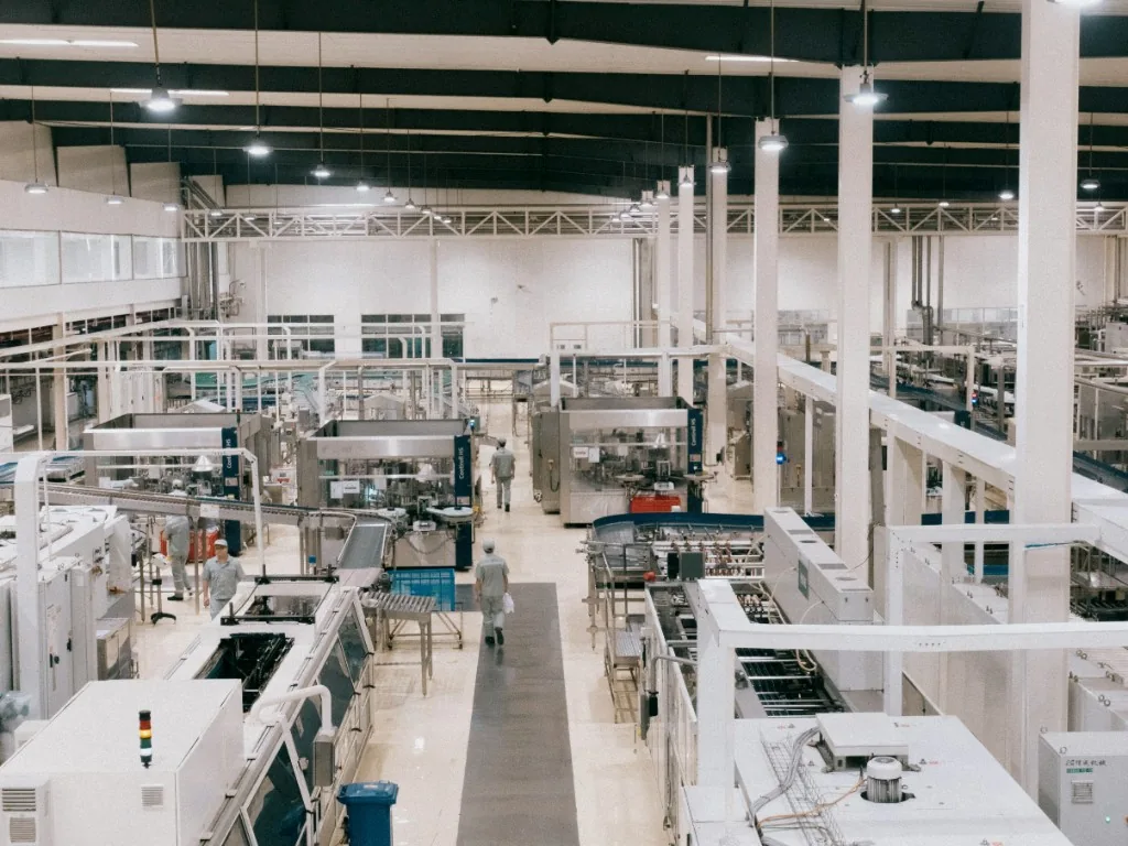 Field technician working on an outdoor utility cabinet beside trees