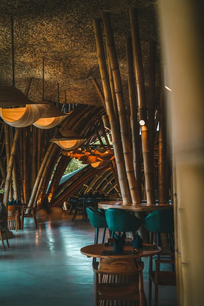 Restaurant interior with bamboo structures, pendant lights, and dining seating